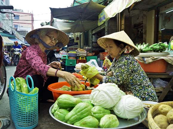 Two women selling vegetables in a marketplace